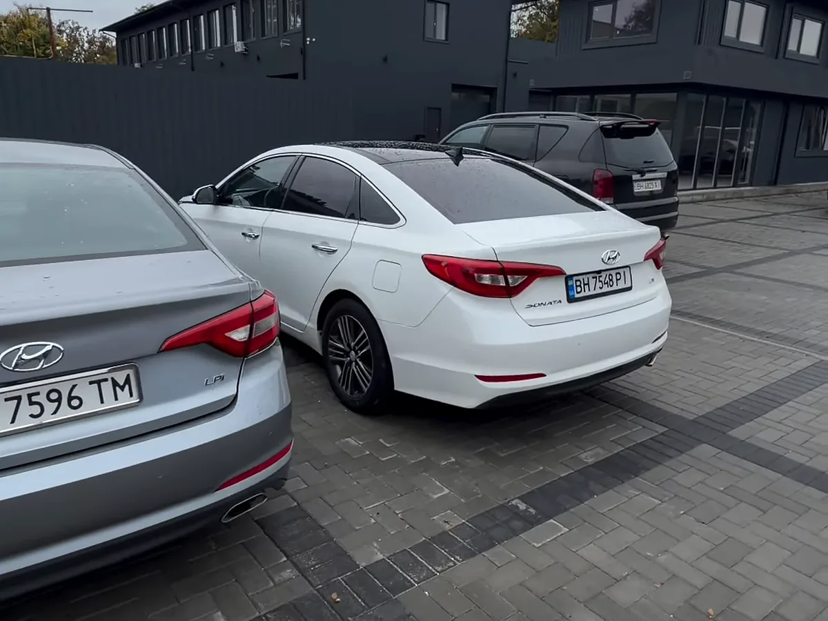 Срібляста та біла Hyundai Sonata у дворі Global